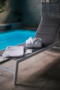 a bench next to a swimming pool with towels on it at Poiana Bucovat in Gura Humorului +93 photos