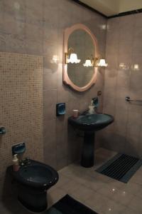a bathroom with a toilet and a sink and a mirror at Palazzo Scavone in Palermo