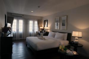 a bedroom with a large white bed and a window at Buri Siri Boutique Hotel in Chiang Mai +71 photos
