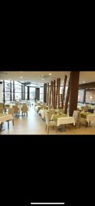 a restaurant with white tables and chairs and windows at Aspen golf studio B402 in Razlog