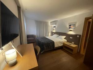 a small hotel room with a bed and a desk at Casa do Ferreiro T3 in Venda Nova