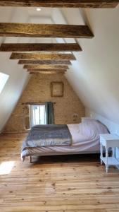 a bedroom with a bed in a loft with wooden floors at La Maison De Jade in Meyrals