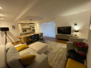 a living room with a white couch and a table at Casa do Ferreiro T3 in Venda Nova