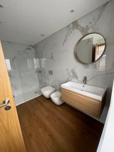 a bathroom with a sink and a toilet and a mirror at Casa do Ferreiro T3 in Venda Nova +36 photos