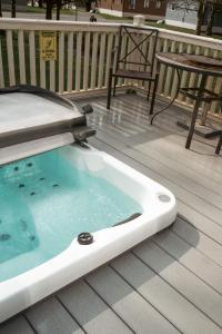 uma banheira de hidromassagem num deque com uma mesa e uma cadeira em JJs Lodge Ebor em Allerthorpe