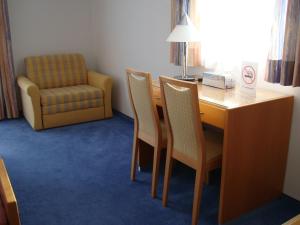a room with a table and chairs and a chair at Pension Demmel, Bed & Breakfast in Bruckmühl