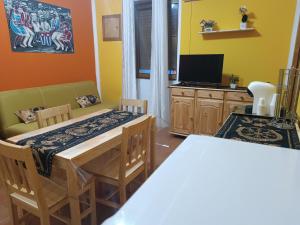 una sala da pranzo con un tavolo e una televisione di i 4 musicisti a Sassari
