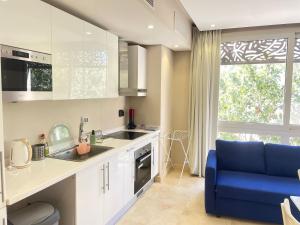 a kitchen with a sink and a blue couch at Cozy 1BD in Mangroovy El Gouna in Hurghada