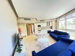 a living room with a blue couch and a table at Cozy 1BD in Mangroovy El Gouna in Hurghada