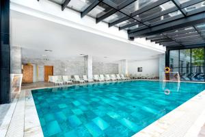 凯麦尔DoubleTree by Hilton Antalya-Kemer All-Inclusive Resort的建筑物内有蓝色水的大型游泳池