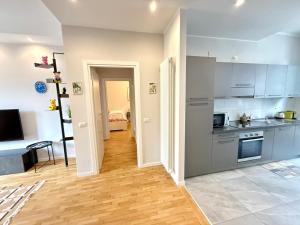 una cucina con armadietti grigi e pavimenti in legno di Comoluxhouse- Intero appartamento a Como