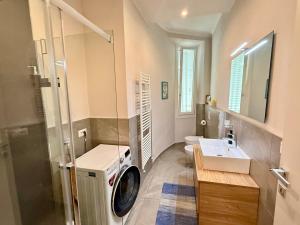 un bagno con lavatrice e lavandino di Comoluxhouse- Intero appartamento a Como