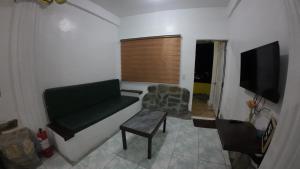 a living room with a couch and a tv at Dream Hill Condos & Spa in Puerto Galera