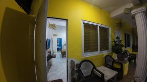 a room with a yellow wall and a table and chairs at Dream Hill Condos & Spa in Puerto Galera