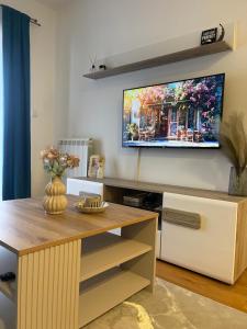 a living room with a tv on the wall at Stan na dan Spasovdanska in Ivanići
