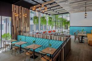 芭东海滩DoubleTree by Hilton Phuket Banthai Resort的餐厅设有蓝色的座位和桌子以及窗户。
