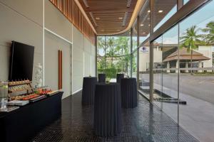 芭东海滩DoubleTree by Hilton Phuket Banthai Resort的大楼的大堂,设有桌子和窗户