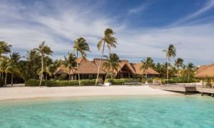 a resort on a beach with palm trees at Waldorf Astoria Maldives Ithaafushi in South Male Atoll