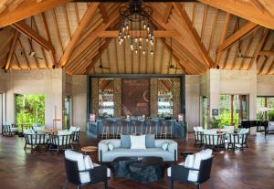 a lobby with a couch and tables and chairs at Waldorf Astoria Maldives Ithaafushi in South Male Atoll
