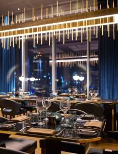 ドバイにあるWaldorf Astoria Dubai International Financial Centreのダイニングルーム(テーブル、椅子、ワイングラス付)