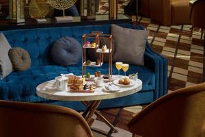 ドバイにあるWaldorf Astoria Dubai International Financial Centreの青いソファ(テーブル、食べ物付)