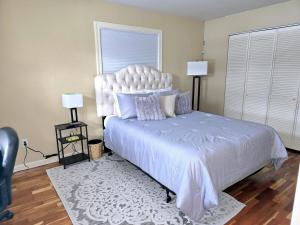 1 dormitorio con 1 cama grande y cabecero blanco en The Little House On E Street, en Anchorage