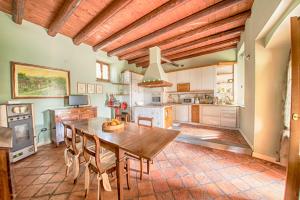 イゼーオにあるAgriturismo Villa Antonellaの木製テーブルと椅子付きの広いキッチン
