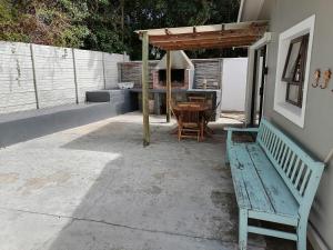 a patio with a table and a bench next to a house at Pearly Beach Cottage in Pearly Beach