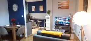 a living room with a couch and a table and a television at Spacious and homely city centre studio in Coventry
