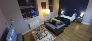 a bedroom with a bed and a couch in a room at Spacious and homely city centre studio in Coventry
