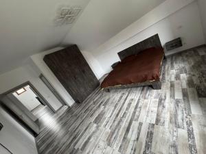 a bedroom with two beds and a wooden floor at Vila Amy - 5 min from THERME and AIRPORT in Corbeanca