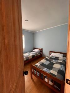 a room with two beds and a door open at Los Molinos Alto in Valdivia