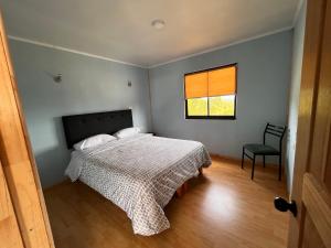 a bedroom with a bed and a window at Los Molinos Alto in Valdivia