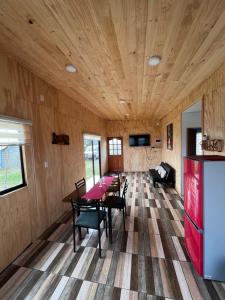 a room with a table and chairs and a refrigerator at Los Molinos Alto in Valdivia