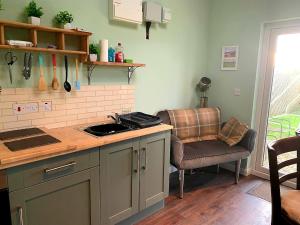 a kitchen with a counter and a chair in a room at Y Caban-The Cabin-2 Guests-Private Parking-Fast WIFI in Llanelli