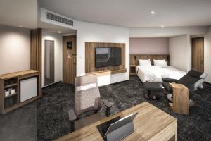 a hotel room with a bed and a desk at Hotel JAL City Nagano in Nagano