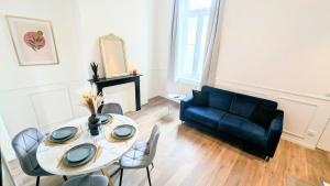 a living room with a table and a couch at L'haussmannien 1er Étage in Abbeville