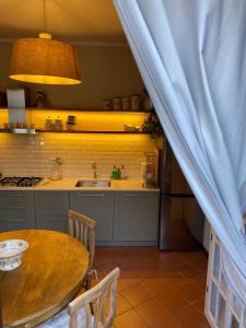 una cucina con un tavolo di legno e un lavello di Il Molo Di Hotel Villa Aurora a Lezzeno