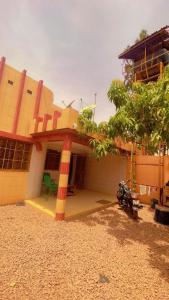 a building with a building with a tree in front of it at AG appart'hôtel villas in Ouagadougou