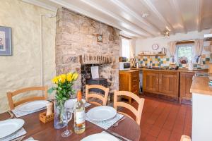 eine Küche und ein Esszimmer mit einem Tisch mit gelben Blumen in der Unterkunft Pwll Cottage in Carmarthen