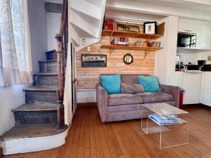 un salon avec un canapé et un escalier dans l'établissement Baie'lle Vue, à Saint-Valery-sur-Somme