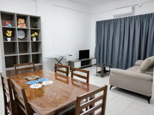 Una sala de estar con una mesa y sillas y un sofá. en IJM Suria Homestay, en Sandakan