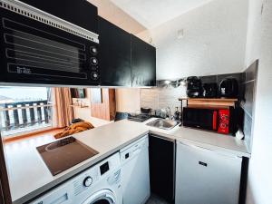 a kitchen with a sink and a stove top oven at Le cocon des 4 saisons Appartement cosy et chaleureux, proche des pistes in Font-Romeu