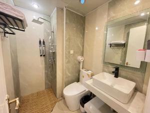 łazienka z toaletą, umywalką i prysznicem w obiekcie Xihe Light Luxury Self-service Apartment w mieście Chengdu