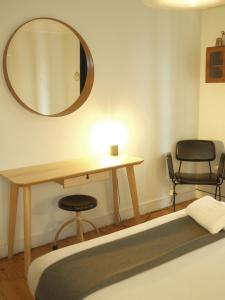 a bedroom with a table and a mirror and two chairs at Goodnight Hostel in Lisbon +51 photos