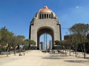 a large building with an arch in a park at Hotel Oxford in Mexico City