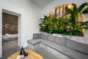 a living room with a couch and plants on the wall at Evgenias Sea House in Symi