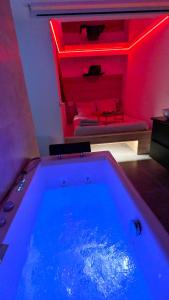 a bath tub with a red lighting in a room at Love nest 1er Étage in Abbeville +22 photos