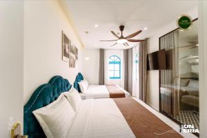 une chambre avec deux lits et un ventilateur de plafond dans l'établissement Chuỗi villa 7 Ngủ Sun feria 888 - bể bơi - BBQ -gần Bãi BIỂN BÃI CHÁY, à Hạ Long