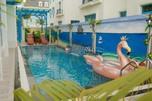 une piscine avec un flamingo au milieu d'un bâtiment dans l'établissement Chuỗi villa 7 Ngủ Sun feria 888 - bể bơi - BBQ -gần Bãi BIỂN BÃI CHÁY, à Hạ Long